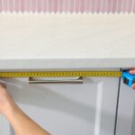 Mètre ruban posé sur un plan de travail de cuisine pour vérifier les dimensions.